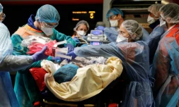 Du personnel soignant embarque un patient contaminé au Covid-19 à bord d'un TGV médicalisé, le 1er avril 2020 à la Gare d'Austerlitz, à Paris