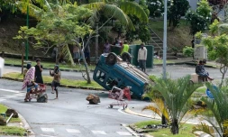 Un habitant dégage une route à Nouméa, le 15 mai 2024