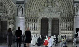 (g-d) La maire de Paris, Anne Hidalgo, le président Emmanuel Macron et son épouse Brigitte Macron devant Notre-Dame de Paris alors que l'archevêque de Paris, Mgr Ulrich, se dirige vers les portes de la cathédrale lors de la cérémonie pour sa réouverture officielle, le 7 décembre 2024 à Paris ( POOL / Christophe PETIT TESSON )