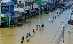Des personnes traversent une rue inondée après de fortes pluies à Wellampitiya, près de Colombo, au Sri Lanka, le 30 novembre 2025 ( AFP / Ishara S. KODIKARA )
