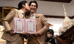 Les acteurs thaïlandais Apiwat "Porsch" Apiwatsayree (gauche) et Sappanyoo "Arm" Panatkool posent après avoir obtenu leur certificat de mariage, le 23 janvier 2025 à Bangkok