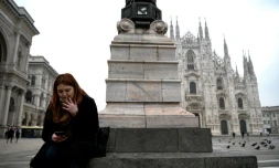 Une femme fume une cigarette sur la place du Duomo, le 19 janvier 2021 à Milan