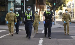 Des policiers et des soldats en patrouille à Melbourne (Australie) le 2 août 2020 aprÚs l'instauration d'un couvre-feu en raison du coronavirus