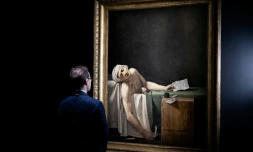 Un visiteur devant le tableau "La mort de Marat" (également connu sous le nom de "Marat Assassiné") du peintre français Jacques-Louis David, le 14 octobre 2025 au musée du Louvre à Paris