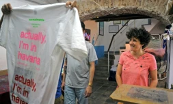 Idania del Rio (d) propriétaire de "La Clandestina" petite boutique d'articles recyclés à La Havane sert un client, le 28 mars 2018