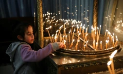 Un enfant allume des bougies à la basilique de la Nativité à Bethléem, en Cisjordanie occupée, le 23 décembre 2019