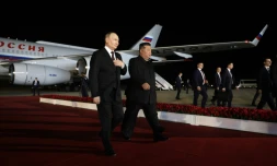 Le dirigeant nord-coréen Kim Jong Un (d) marche au cÎté du président russe Vladimir Poutine lors d'une cérémonie de bienvenue à l'arrivée de ce dernier à l'aéroport de Pyongyang, tÎt le 19 juin 2024