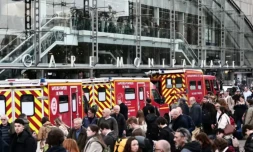 Des pompiers et passagers devant la Gare Montparnasse, partiellement évacuée aprÚs le tir d'un policier contre un hommme armé d'un couteau le 14 novembre 2025 à Paris ( AFP / Thibaud MORITZ )