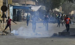 Des manifestants proches de l'opposition au Niger jettent des pierres lors de heurts avec la police à Niamey, le 24 février 2021