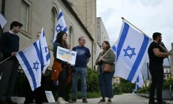 Des personnes brandissent des pancartes et des drapeaux israéliens en signe de soutien devant le Musée juif de Washington, aux Etats-Unis, le 22 mai 2025 ( AFP / Drew ANGERER )