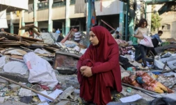 Une femme est assise au milieu des décombres après le bombardement d'une école à Gaza-ville, le 26 mai 2025 ( AFP / Omar AL-QATTAA )