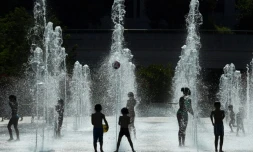 Des enfants dans des jets d'eau au Parc André Citroën à Paris le 26 juillet 2018