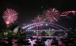Le « feu d'artifice familial » illumine l'Opéra et le pont du port de Sydney trois heures avant le spectacle principal, à minuit à Sydney, le soir du Nouvel An, le 31 décembre 2025 ( AFP / Saeed KHAN )
