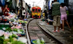 Un train de passagers traverse le marché de Maeklong dans la province de Samut Songkhram, le 4 juin 2022 en Thaïlande