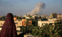 Une Palestinienne regarde de la fumée s'élever aprÚs une frappe isaélienne au sud de la ville de Gaza le 11 juin 2024