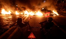 Des manifestants libanais devant des pneus enflammés, sur une route allant de Beyrouth à Byblos, le 21 janvier 2020