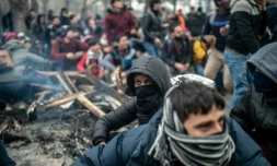 Des migrants attendent dans la zone-tampon entre la Turquie et la Grèce après des heurts avec les forces de l'ordre grecques tentant de les empêcher de franchir la frontière à Kastanies/Pazarkule, le 29 février 2020