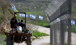 Des agriculteurs palestiniens sur leur tracteur passent prÚs d'un grillage installé par des colons israéliens dans le village de Burqa, prÚs de Naplouse, dans le nord de la Cisjordanie occupée, le 15 février 2026