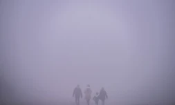 Quatre personnes marchent prĂšs de Pristina au moment oĂč la capitale du Kosovo connaĂźt un fort taux de pollution, le 9 janvier 2022