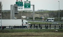 Des migrants marchent sur l'autoroute A16, le 3 décembre 2015 à Coquelles, dans le Pas-de-Calais