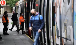 Des passagers portant le masque descendent d'un métro le 23 juin 2021 à Sydney où de nouvelles restrictions sont en vigueur
