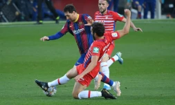La star du Barça Lionel Messi taclé par le défenseur de Grenade German Sanchez, le 29 avril 2021 à Barcelone     