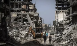 Des Palestiniens longent des bùtiments détruits dans une rue de Khan YounÚs, dans le sud de la bande de Gaza, le 23 avril 2024. ( AFP / - )