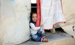 Une jeune syrienne sort d'une tente dans un camp de réfugiés de la Békaa, dans l'est du Liban, le 15 juillet 2016