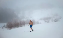 L'archéologue serbe Vladimir Stevanovic marche dans une épaisse couche de neige, en short et chaussures de randonnée, sur le mont Besna Kobila, près de la ville de Vranje, le 30 janvier 2026 en Serbie ( AFP / Oliver BUNIC )