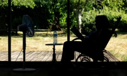 Une personne ùgée assise face à un ventilateur à Pont-Audemer, dans l'Euroe, le 12 juillet 2026 lors d'une vague de chaleur en France