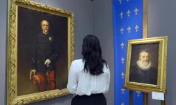Une femme regarde un peinture d'Henri d'Orléans (G) et du roi Henri IV chez Sotheby's à Paris le 18 septembre 2015