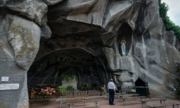 Un pÚlerin prie devant la Grotte du Sanctuaire de Lourdes, le 14 août 2020 dans les Hautes-Pyrénées