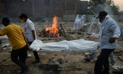 Des proches assistent à la crémation d'une personne décédée du Covid-19 au crematorium de New Delhi le 11 mai 2021