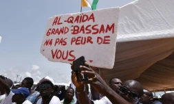 Des Ivoriens portent une pancarte "Al-Qaïda, Grand-Bassam n'a pas peur de toi", lors d'un hommage aux victimes de l'attaque jihadistes du 13 mars 2016 qui a fait 19 morts, le 20 mars 2016 à Grand-Bassam en Côte d'Ivoire