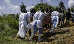 Des agents de santé, équipés de vêtements de protection, transportent vers le cimetière le cercueil d'une personnes suspectée d'avoir succombé à la maladie d'Ebola, à Bunia, dans l'est de la République démocratique du Congo, le 25 mai 2026