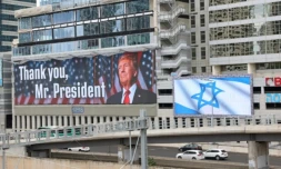 Un panneau d'affichage à Tel-Aviv montre une photo du président américain Donald Trump avec l'inscription "Merci, président Trump" et un autre arbore le drapeau israélien, après l'accord sur Gaza, le 9 octobre 2025 ( AFP / Jack GUEZ )