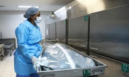 Une employée de morgue et le corps d'une victime du covid dans un hÎpital de POrto Alegre (Brésil) le 4 mars 2021