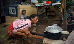 Une femme prépare le dßner prÚs d'une tombe, le 21 mai 2019 dans un vieux cimetiÚre de Phnom Penh, au Cambodge