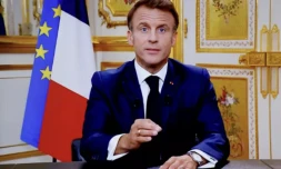 Le président Emmanuel Macron vu sur un écran de télévision lors d'une allocution télévisée le 12 octobre 2023, à Paris ( AFP / Ludovic MARIN )