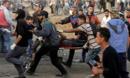 Un manifestant palestinien évacué après avoir été blessé lors de heurts avec les forces de sécurité israéliennes à la frontière entre la bande de Gaza et Israël, le 13 avril 2018