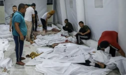 Des gens s'occupent de corps de personnes tuées dans une frappe israélienne sur l'hÎpital Ahli Arab, dans la ville de Gaza, transportés dans l'hÎpital d'Al Chifa le 17 octobre 2023 ( AFP / Dawood NEMER )