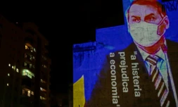 Une image du président brésilien Jair Bolsonaro, accompagné de la phrase "l'hystérie fait du mal à l'économie", est projetée sur le mur d'un immeuble à Sao Paulo le 21 mars 2020, dans le cadre de plusieurs actions critiquant la position du chef de l'Etat