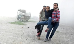 Des Syriens transportent un homme blessé par des bombardements du régime syrien sur la localité rebelle de Aïn tarma dans la Ghouta orientale près de Damas, le 21 mars 2018