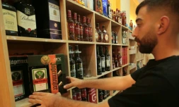Un commerçant dispose des bouteilles d'alcool dans sa boutique de Qamichli, ville kurde du nord-est de la Syrie, le 18 août 2026