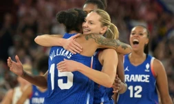 Gabby Williams (G) et Marine Johannes (D) s'enlacent aprÚs la qualification des Bleues du basket pour les demi-finales du tournoi olympique, le 7 août 2024 à Bercy