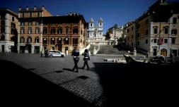 Des policiers en patrouille sur la Place d'Espagne déserte, le 1er avril 2020 à Rome