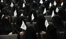 Des étudiantes afghanes en niqabs noirs, un drapeau taliban à la main, écoutent un discours lors d'un rassemblement pro-talibans à l'université Shaheed Rabbani, le 11 septembre 2021 à Kaboul