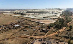 Vue aérienne de parcelles agricoles et de talus miniers en arrière-plan, dans le quartier de Snake Park, à Soweto, le 30 mai 2025 en Afrique du Sud