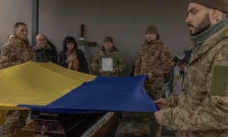 Des soldats ukrainiens portent un drapeau ukrainien au-dessus du cercueil d'un de leurs camarades tués prÚs d'Avdiïvka, le 24 février 2024 à Boutcha en Ukraine