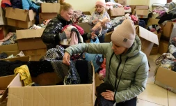 Des dĂ©placĂ©es ukrainiennes cherchent des vĂȘtements dans des cartons dans un centre d'aide Ă Lviv, le 11 avril 2022 en Ukraine
